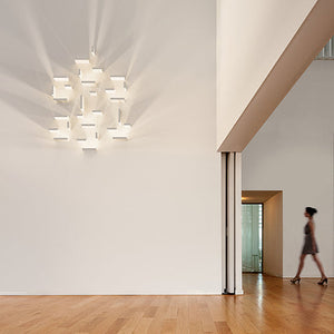 Composizione Set di Vibia installata sulla parete di un ampio open space, che crea un gioco di luce e ombra d'atmosfera.