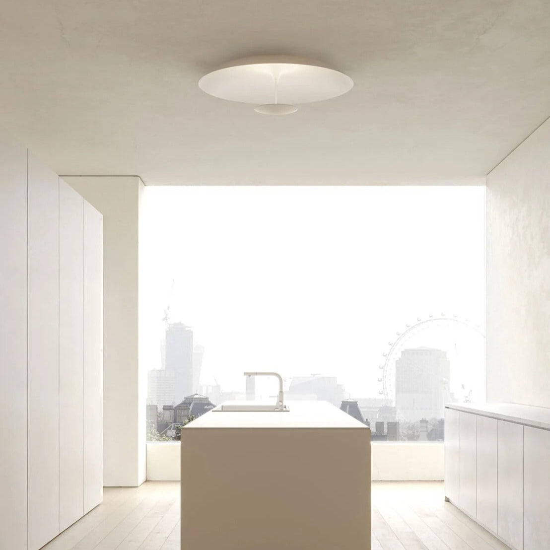 Plafoniera bianca di Karman illumina l'isola di una cucina minimalista