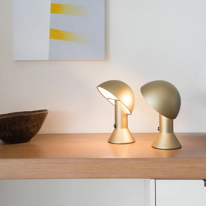 Coppia di lampade Elemetto colore oro posizionate su una moderna Madia in legno.