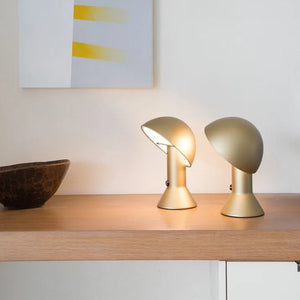 Coppia di lampade Elemetto colore oro posizionate su una moderna Madia in legno.