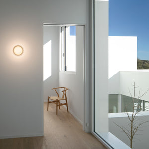 Effetto luminoso dell'applique Dots Glass su parete texture con bagliore lunare diffuso