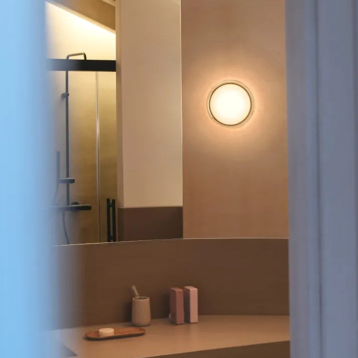 Applique Dots in vetro di Vibia installata in un bagno dall'atmosfera accogliente.