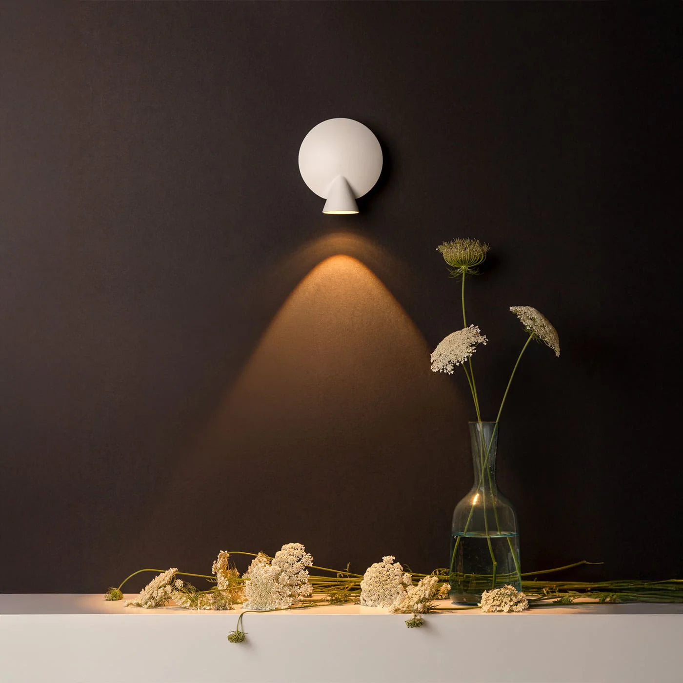 Fascio di luce direzionato dalla lampada Tortuga su un tavolo.
