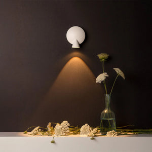 Fascio di luce direzionato dalla lampada Tortuga su un tavolo.
