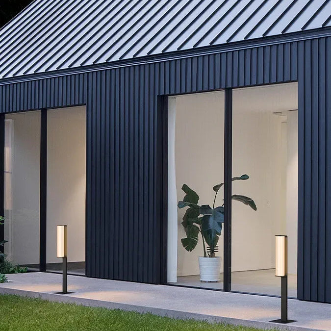 Lampada paletto installata in un giardino di una casa dal design nordico.