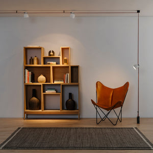 Installazione del sistema Plusminus di Vibia in un ampio soggiorno, con il nastro che attraversa la stanza e diversi punti luce.