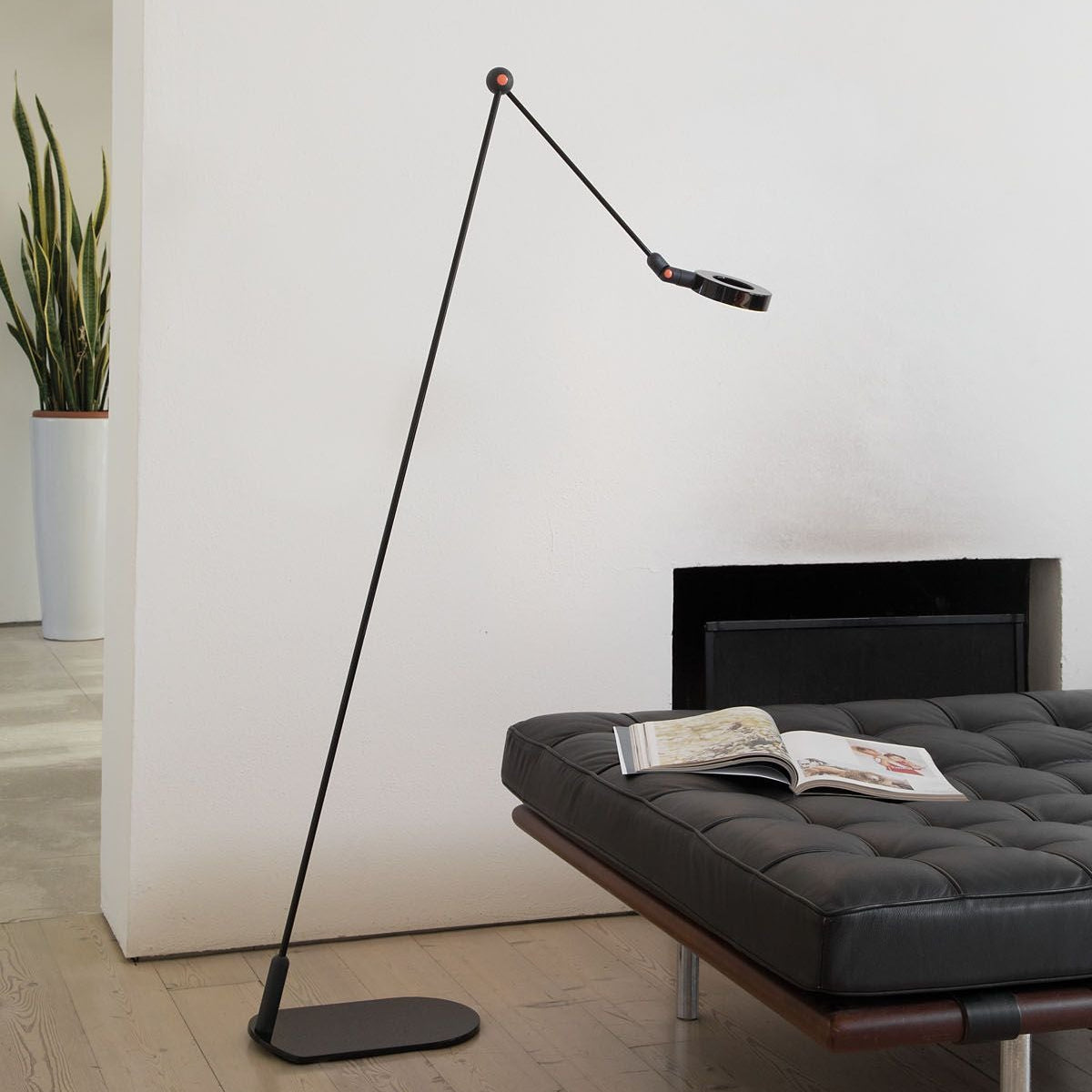 Elegante lampada da terra disegnata da Martinelli Luce, posizionata in un salotto dal design minimal.