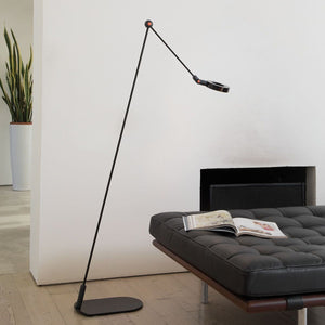 Elegante lampada da terra disegnata da Martinelli Luce, posizionata in un salotto dal design minimal.