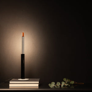 Lampada da tavolo Metrica posizionata su una credenza, con la sorgente luminosa estratta.
