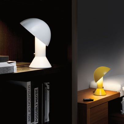 Lampada di design Elmetto gialla posizionata su un comodino accanto a un letto, ideale per la lettura serale