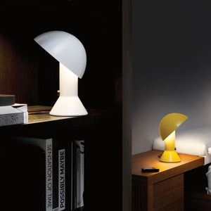 Lampada di design Elmetto gialla posizionata su un comodino accanto a un letto, ideale per la lettura serale