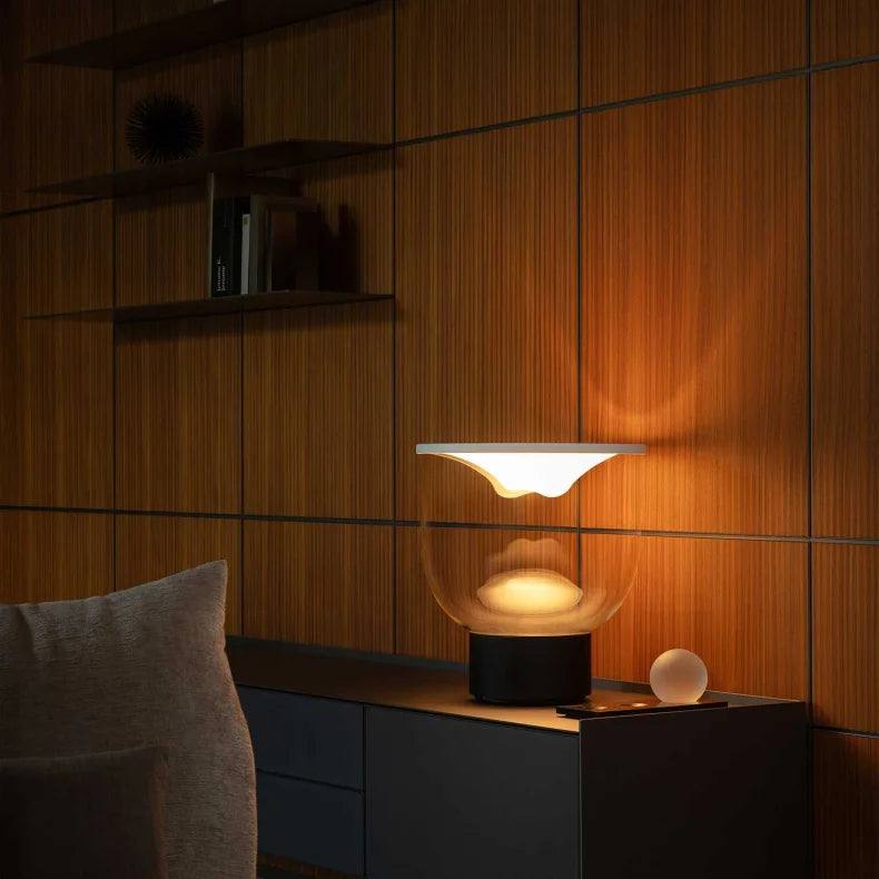 Lampada interattiva Grammoluce accesa su una credenza in un soggiorno moderno.