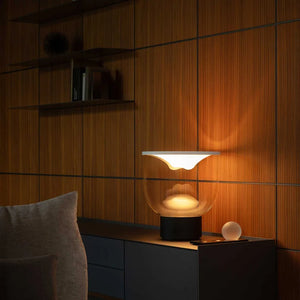 Lampada interattiva Grammoluce accesa su una credenza in un soggiorno moderno.
