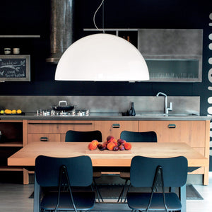 Lampada a sospensione di design Blow installata sopra un tavolo da pranzo in un ambiente moderno e luminoso. 