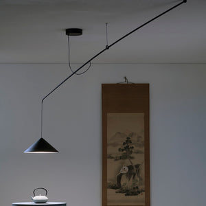 Lampada a sospensione VELA di Martinelli Luce installata sopra un tavolo da pranzo in un living open space. 