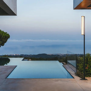 Lampione Class Vibia versione 1 cilindro su terrazza contemporanea con piscina, atmosfera serale accogliente.