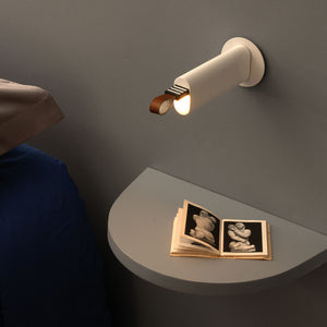 Luce estraibile posizionata sopra un comodino in camera da letto.