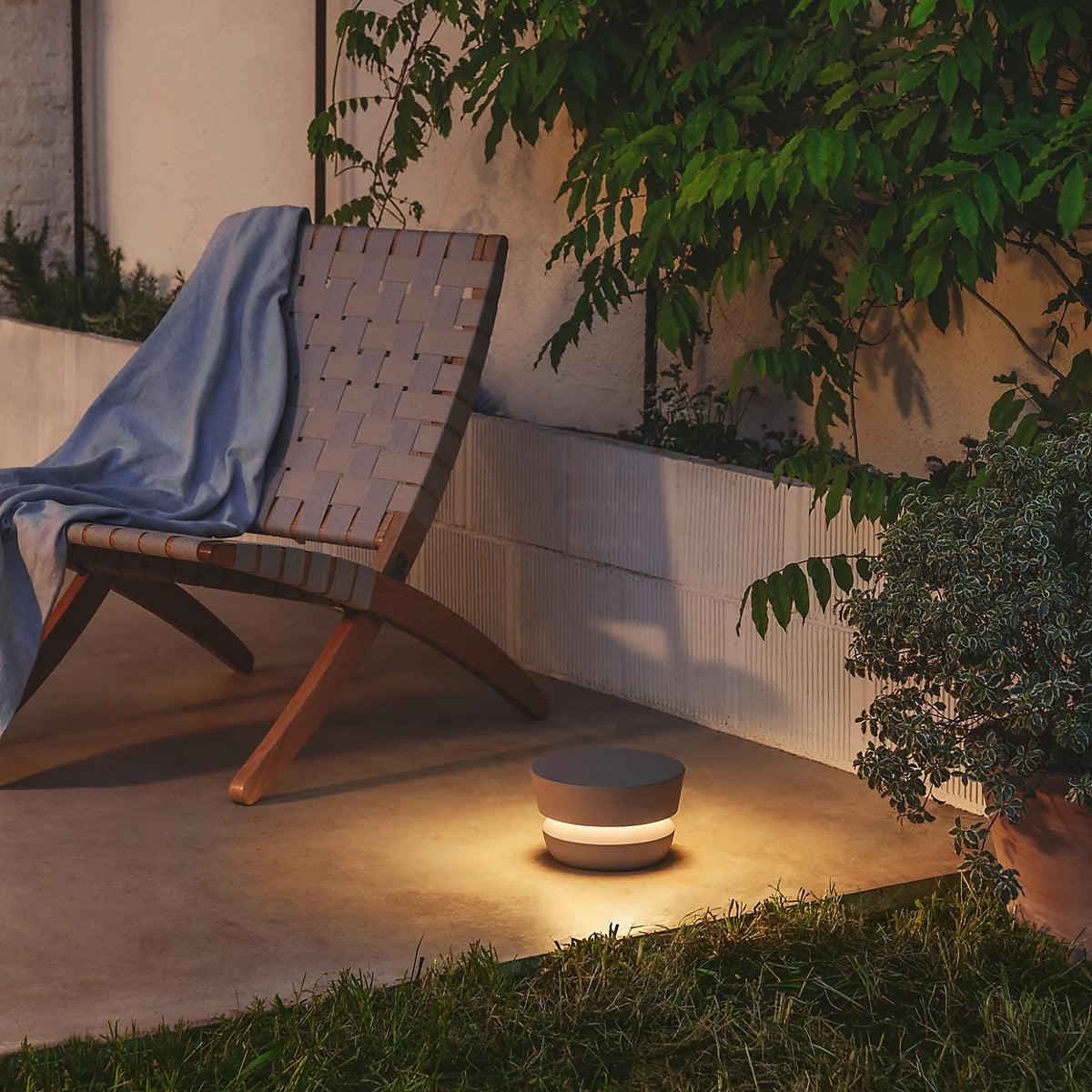 Dots Outdoor 4700 con luce circolare che creano isole di luce d'atmosfera all'interno di un giardino curato.