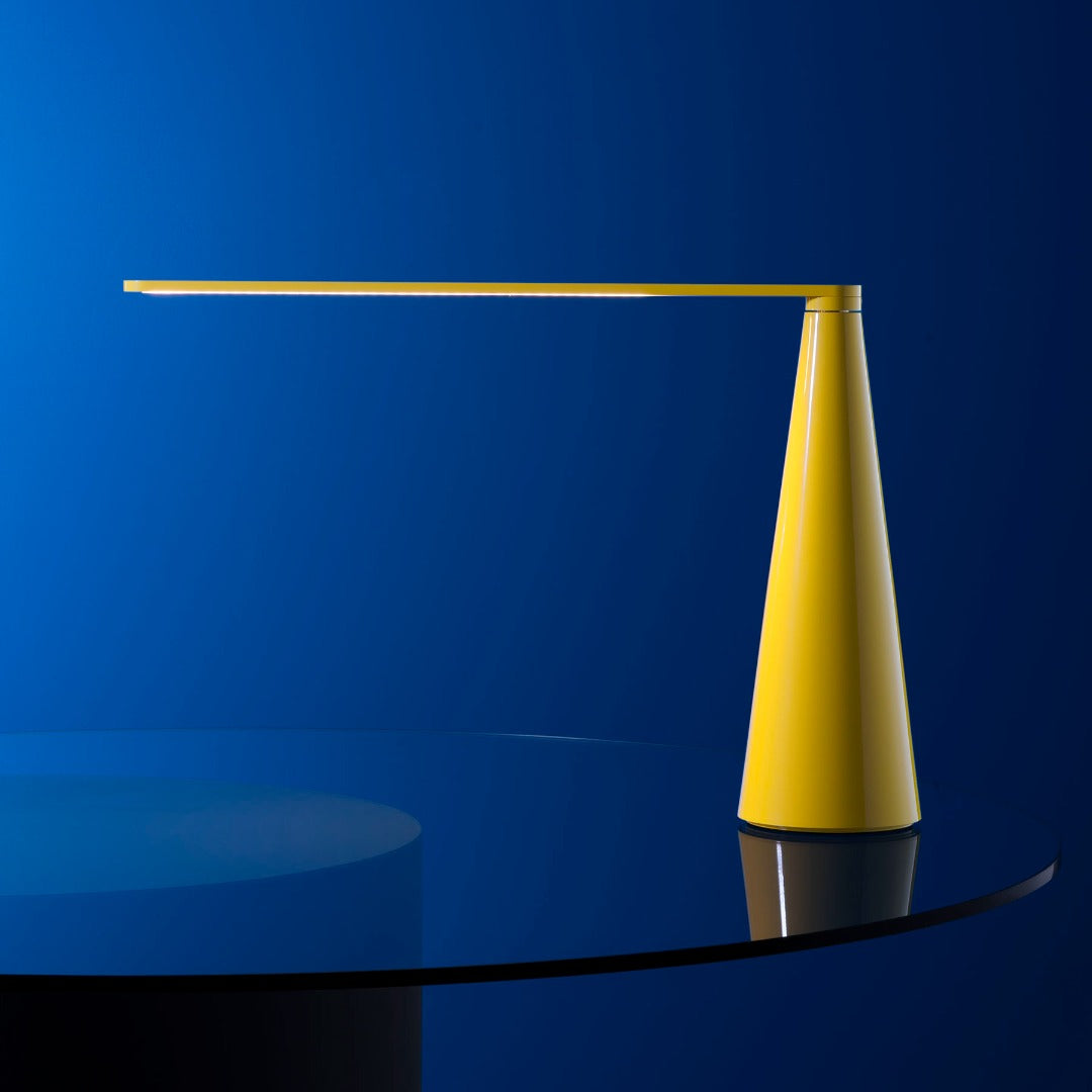 Lampada da tavolo Elica nella versione gialla posizionata su un elegante tavolino in vetro