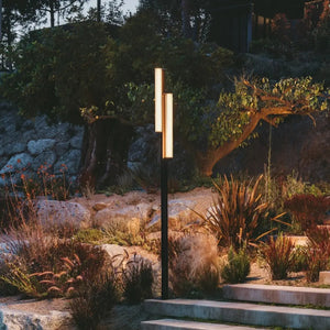 Paletto alto Class Vibia installato in giardino moderno di sera con luce calda 2700K che illumina percorso in pietra naturale