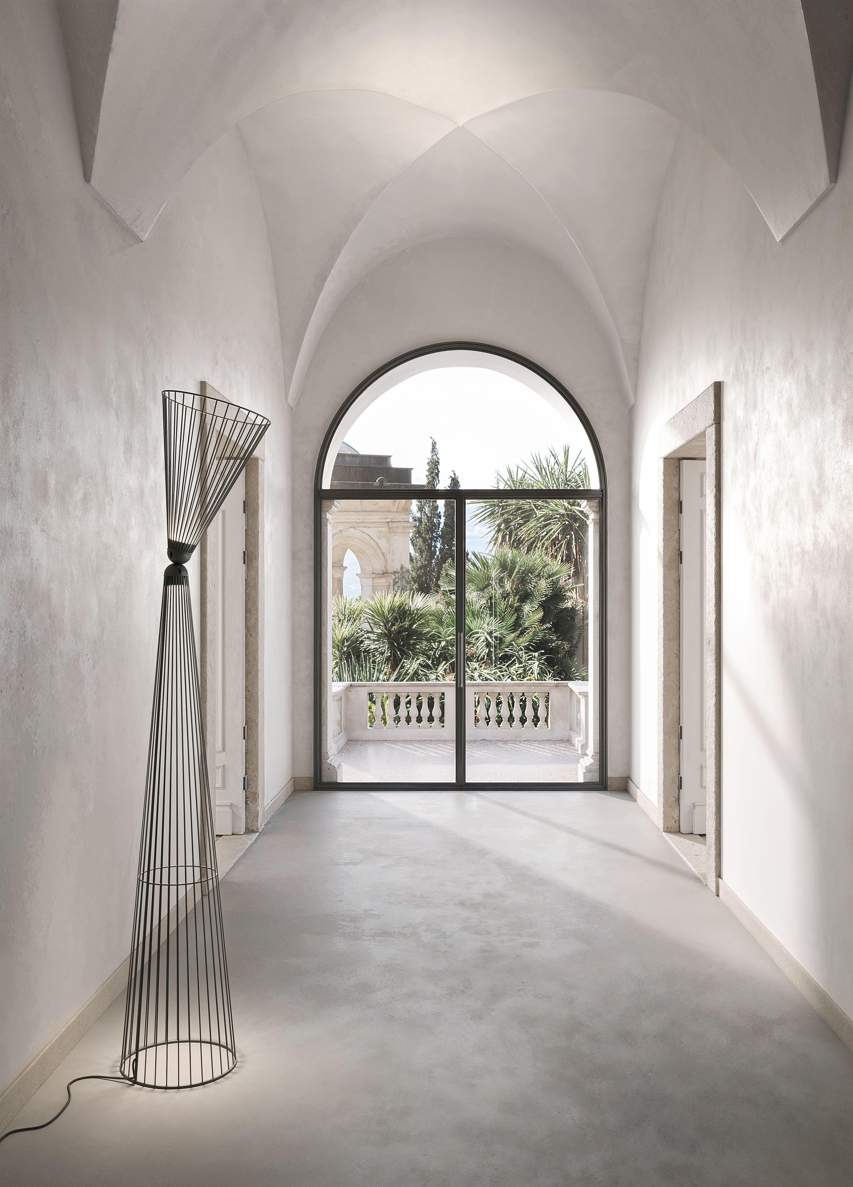 Elegante piantana da interno di Karman perfettamente integrata in uno spazio con soffitto a volta.