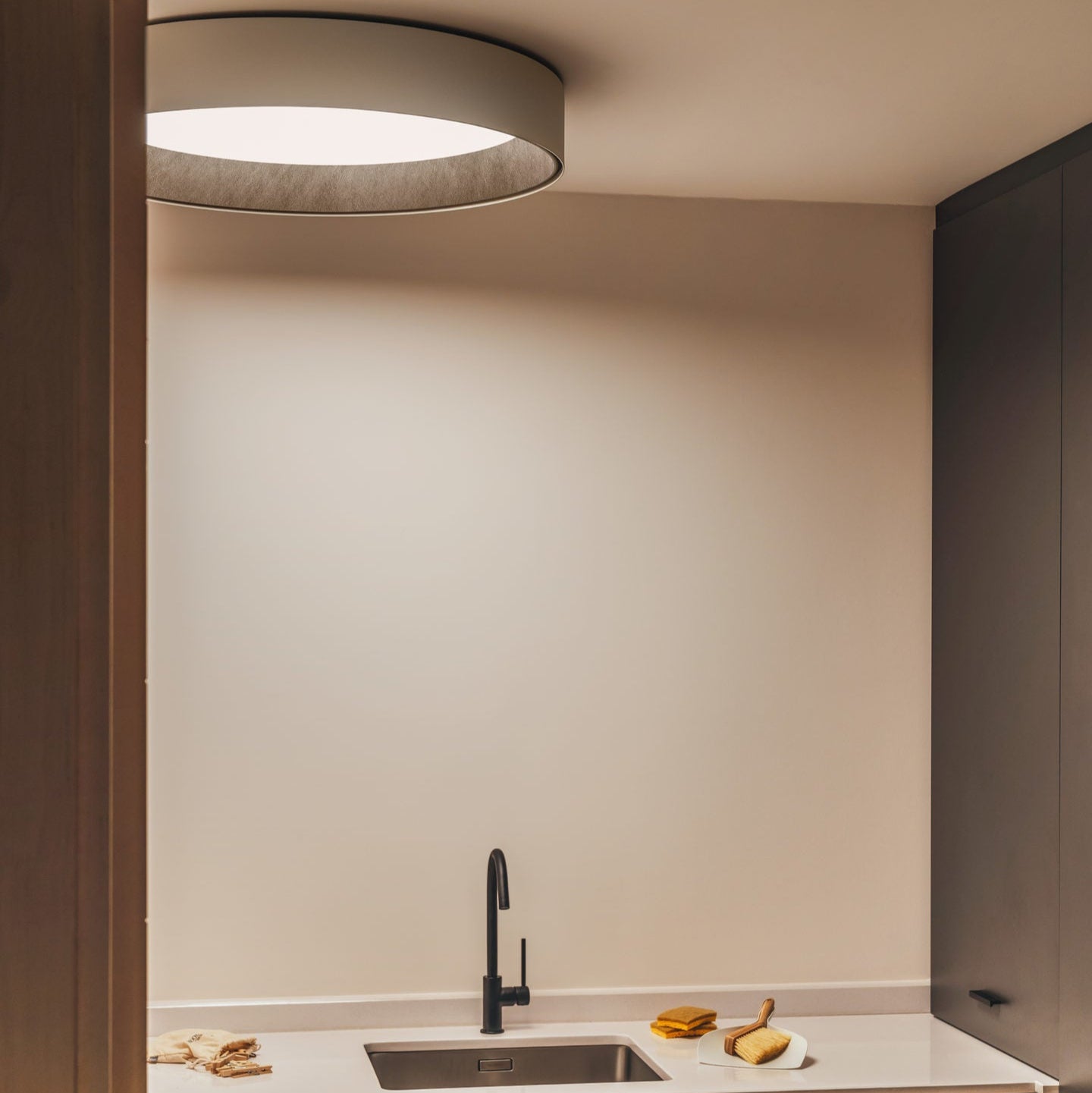 La plafoniera nella versione grande di VIBIA illumina una cucina dal design minimale.