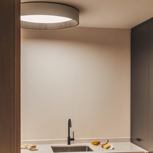 La plafoniera nella versione grande di VIBIA illumina una cucina dal design minimale.