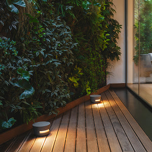 Serie di segnapasso Dots Outdoor 4697 che illuminano un camminamento in legno con un fascio di luce laterale.