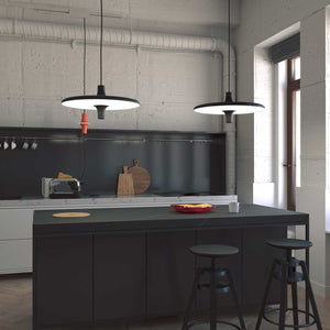 Sospensione di design Avro con presa elettrica installata sopra l'isola di una cucina.